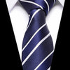 A dark blue silk jacquard tie with white diagonal stripes worn against a white shirt.