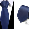 Dark blue silk jacquard necktie folded and displayed against a white background.