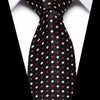Black silk jacquard tie with small red and white polka dots shown against a white shirt.