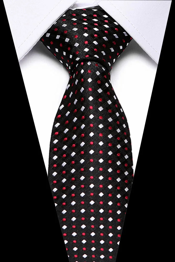 Black silk jacquard tie with small red and white polka dots shown against a white shirt.