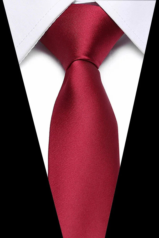 A close-up of a deep red silk jacquard tie with a white collar visible.