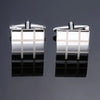 A pair of silver cufflinks featuring a square design with a checkered pattern.