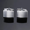 A pair of silver-toned men's classic square cufflinks displayed against a dark gray background.