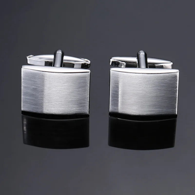 A pair of silver-toned men's classic square cufflinks displayed against a dark gray background.