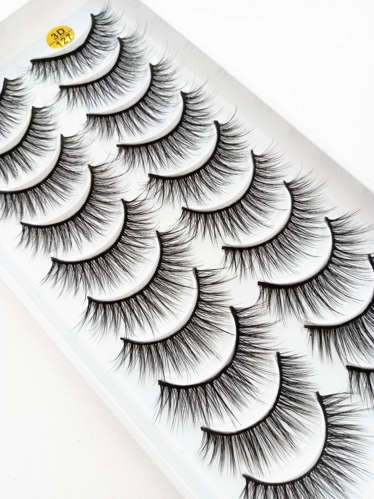 A close-up of dramatic mink false eyelashes displayed on a white surface.
