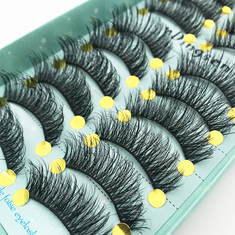 A display of black mink false eyelashes arranged on a light green tray.