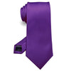 Cravate en soie jacquard violette roulée et présentée sur fond blanc.
