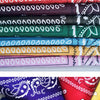 Una pila de pañuelos o bufandas de tela coloridas con varios patrones y colores.