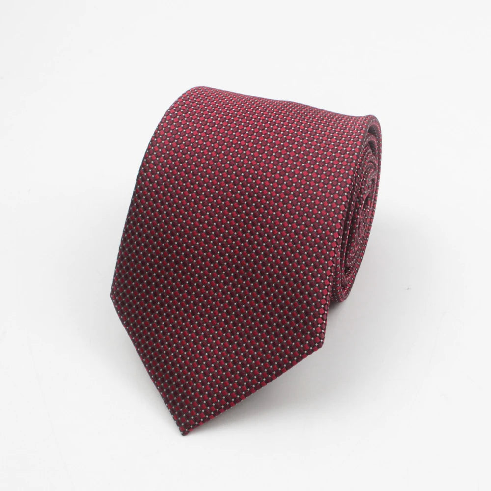 A dark red necktie with a small repeating dot pattern folded neatly.