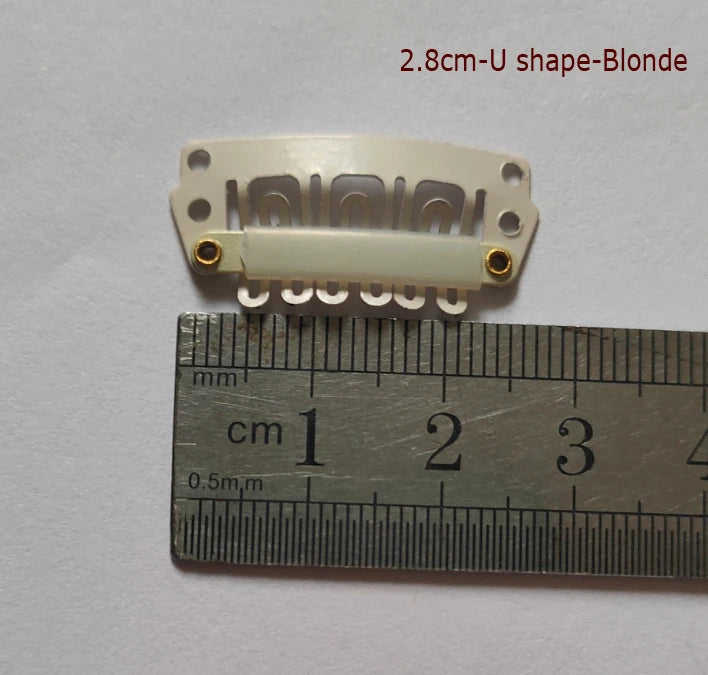 Pince d'extension capillaire en forme de U blanche, étiquetée 2,8 cm Blonde, à côté d'une règle.