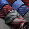 A close-up display of various patterned men's ties in shades of blue, red, and black stripes and plaids.