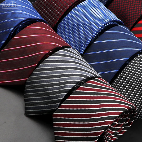 A close-up display of various patterned men's ties in shades of blue, red, and black stripes and plaids.