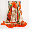 A luxurious satin silk scarf in orange and green tones draped vertically.