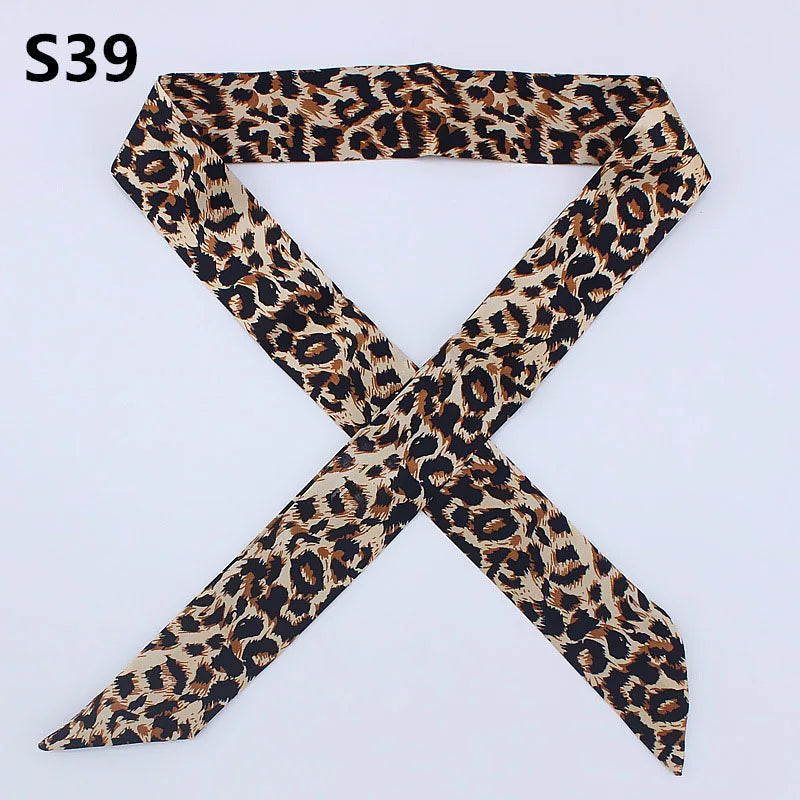 A black and brown leopard print silk headband or scarf tied in an 'X' shape.