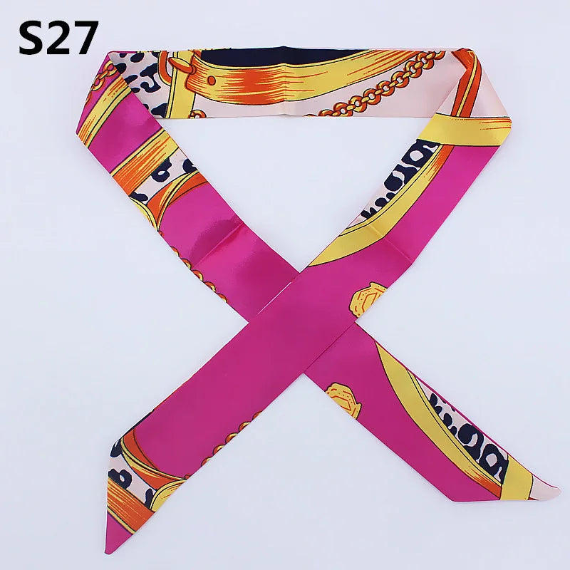 A pink silk headband scarf with a multi-color leopard print pattern, folded in an 'X' shape.