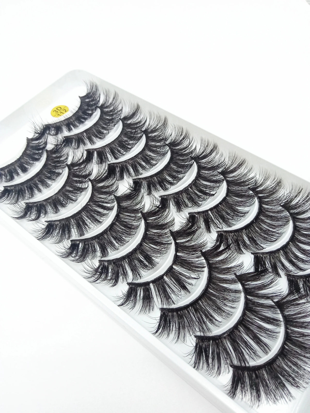 A display of dramatic mink false eyelashes arranged in a fan pattern on a white tray.