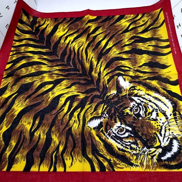 Pañuelo de bandana con estampado de tigre amarillo y negro, con cara felina detallada.