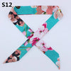 A silk headband scarf featuring a multi-color floral print with shades of pink, green, and teal.
