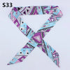 A patterned silk headband scarf featuring multi-color geometric and abstract designs.