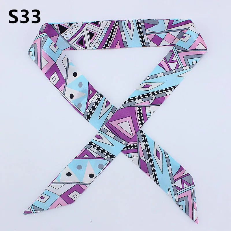 A patterned silk headband scarf featuring multi-color geometric and abstract designs.