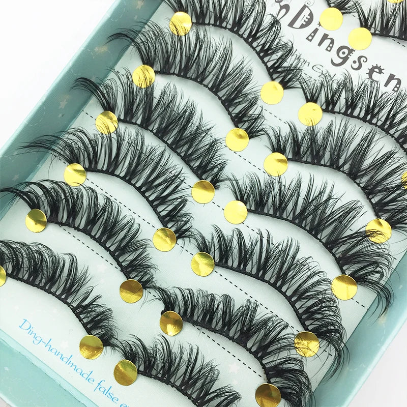 A display of black mink false eyelashes arranged on a light blue surface.