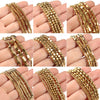 Various strands of gold-plated hematite round cube beads for DIY jewelry displayed on hands.