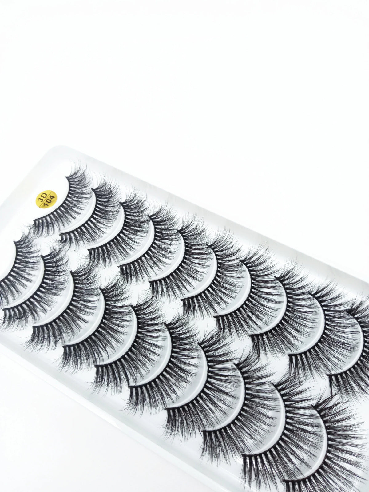 A strip of dramatic mink false eyelashes is shown on a white packaging or display.