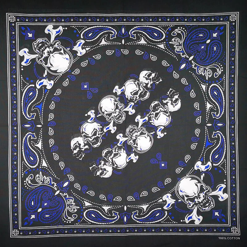 Estampado de tela oscura con calaveras blancas y patrones decorativos azules sobre fondo negro.