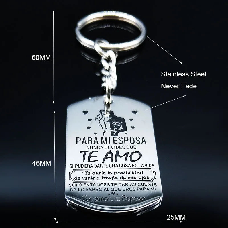 A silver stainless steel keychain featuring an engraved message in Spanish and a silhouette of a couple.