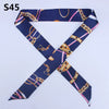 A navy blue silk headband scarf featuring a multi-color chain print in a cross design.