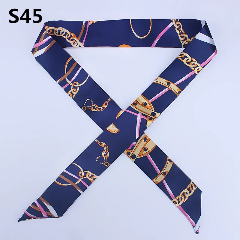 A navy blue silk headband scarf featuring a multi-color chain print in a cross design.