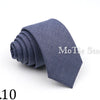 A dark blue solid color tie folded neatly on a white background.