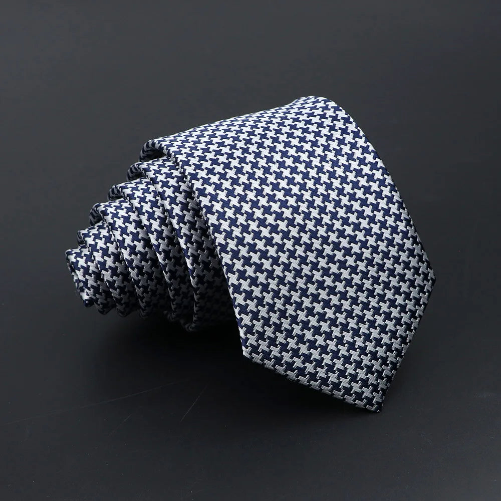 A stack of classic men's tie featuring a blue and white plaid dot pattern.