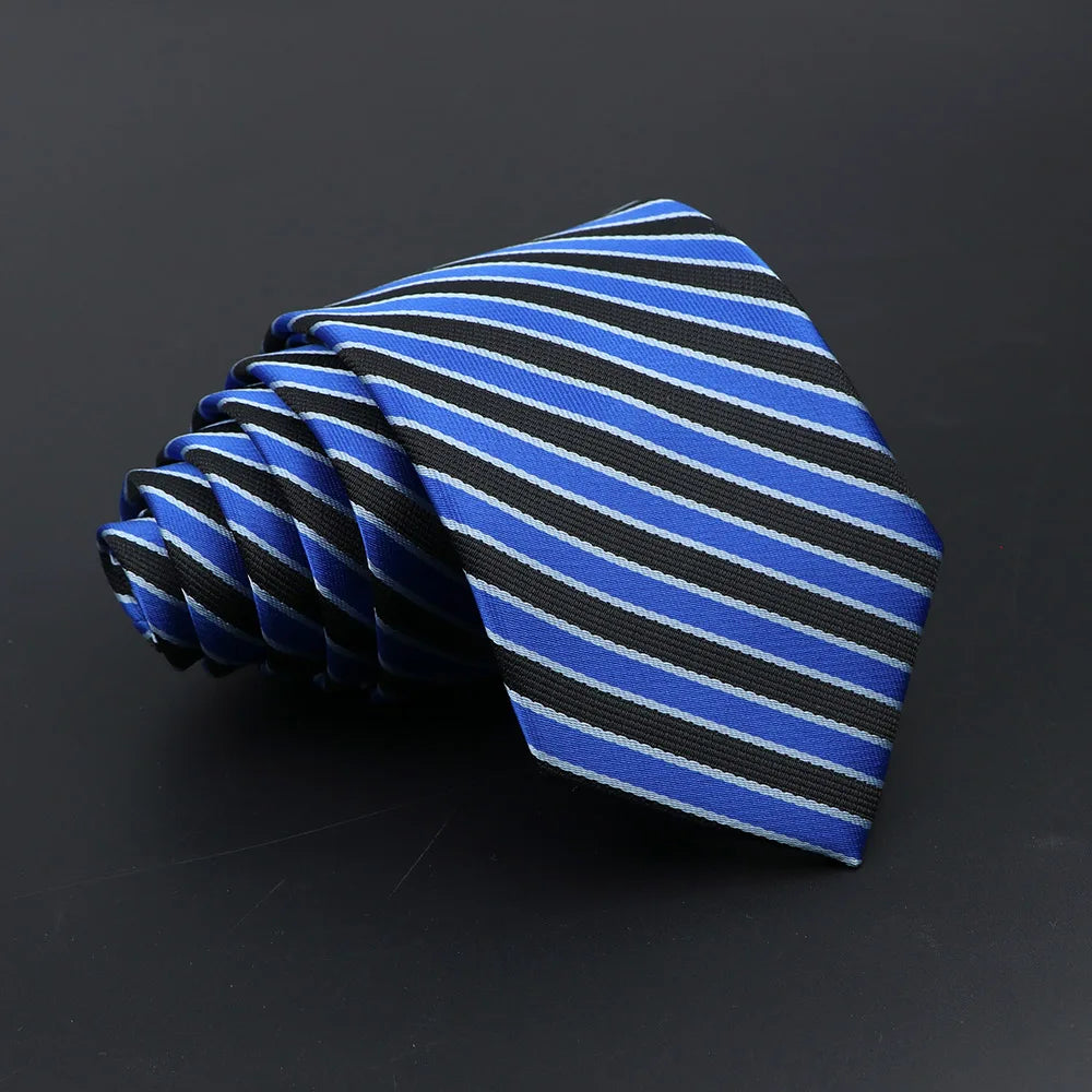 A folded blue and black striped necktie on a dark background.