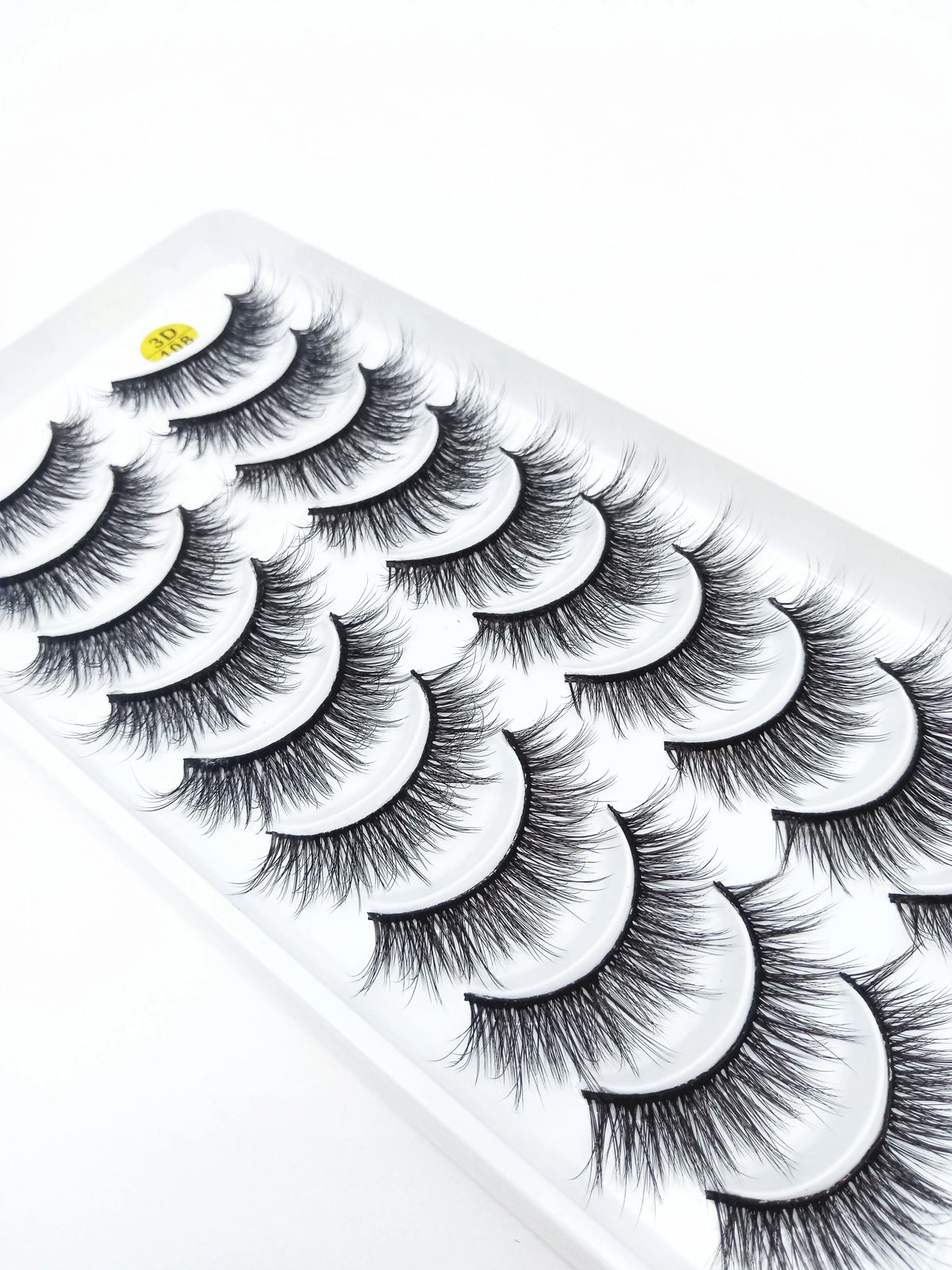 A strip of dramatic mink false eyelashes displayed on a white plastic tray.