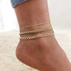Three layered gold stainless steel anklets worn on a person's ankle.
