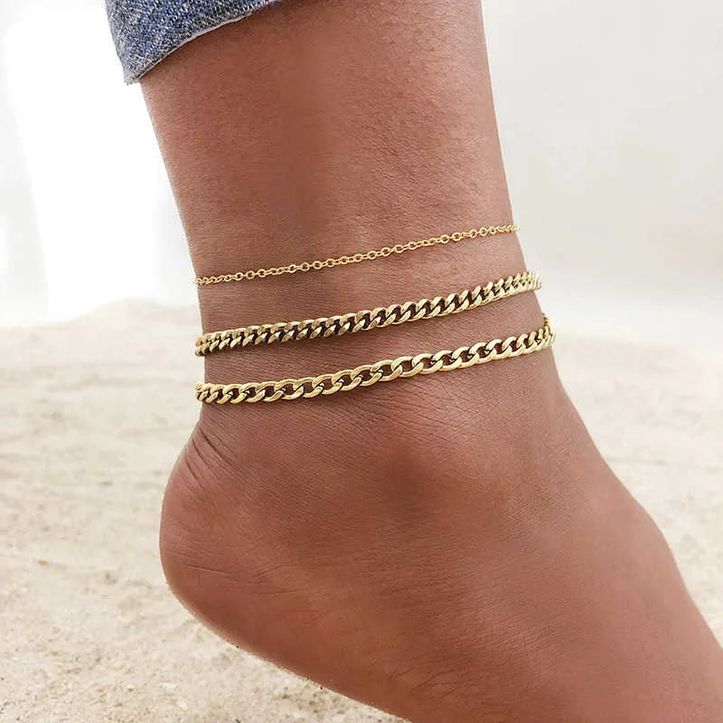 Three layered gold stainless steel anklets worn on a person's ankle.