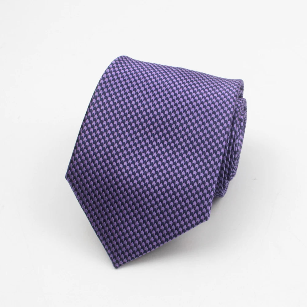 A purple patterned necktie with a textured weave is shown folded on a white background.