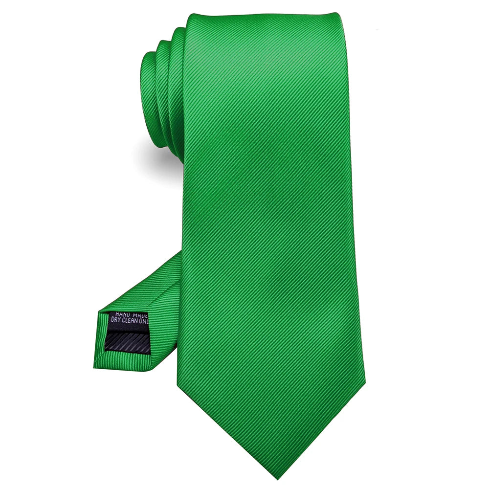 Cravate en soie jacquard vert vif roulée et présentée sur fond blanc.