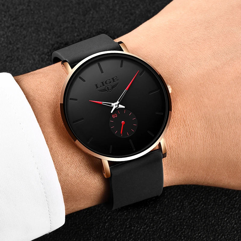 A black LIGE quartz sport watch with a gold-tone case and black strap worn on a wrist.