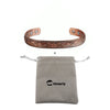 A pure copper magnetic bangle with a plum flower design next to a gray pouch labeled Vinterly.