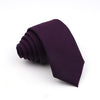 A dark purple men's tie folded neatly on a white background.