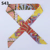 A silk headband scarf featuring a multi-color leopard print design in yellow, pink, and orange patterns.