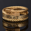 A gold-toned stainless steel bracelet featuring a woven design and Roman numerals.