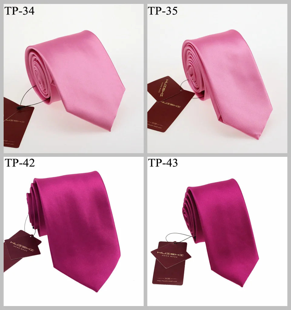 Eine Sammlung rosa und magentafarbener Satin-Halsbinden in verschiedenen Falten und Farben.