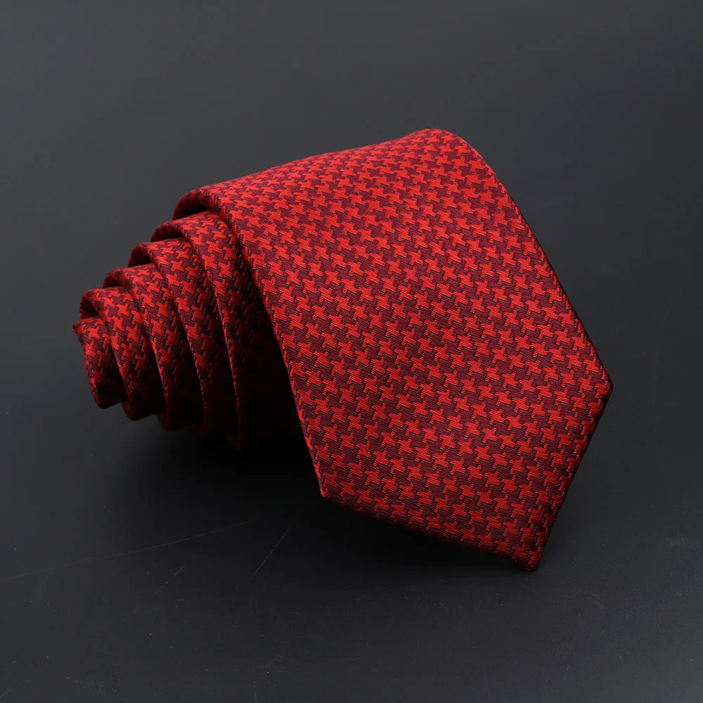 A red plaid patterned men's tie rolled into a conical shape.