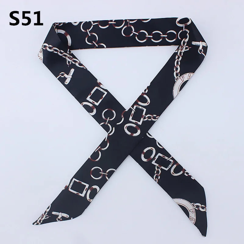 Black silk scarf with a multi-color chain print tied in an 'X' shape