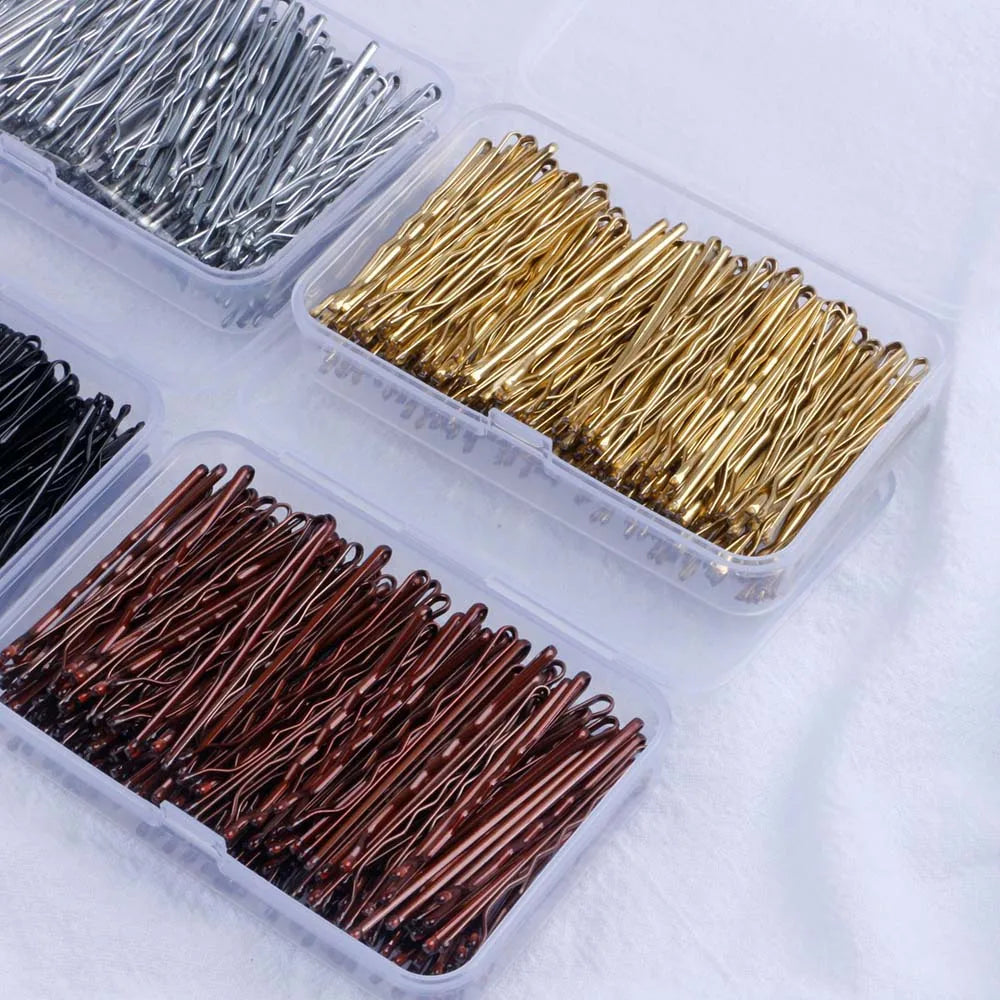 Three clear containers hold various strands of elegant metal hair clips in silver, gold, and copper tones.
