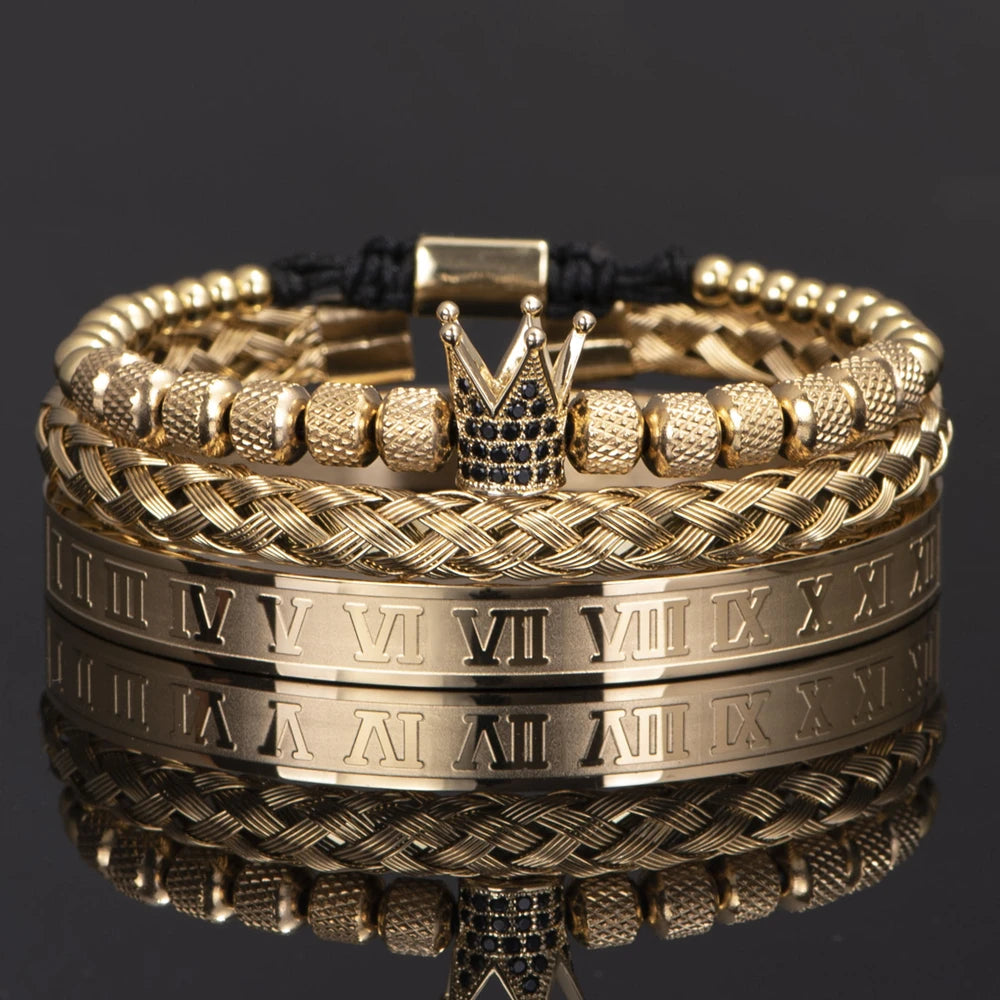 Pulseras de esmalte dorado y negro con números romanos apilados sobre una superficie reflectante.