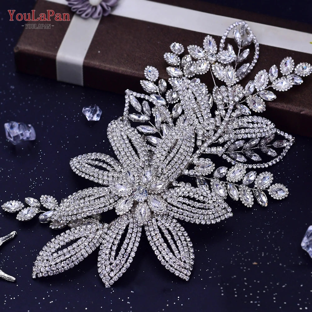 Glitzernde silberne Strass-Brauttiara mit filigranen floralen und blattartigen Designs auf dunkler Oberfläche.